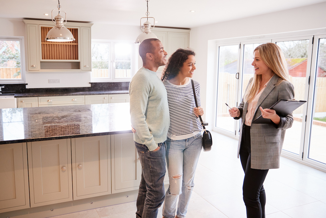 Three people discussing real estate in house for sale